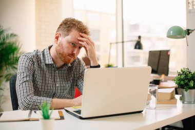 İşyerinde çalışan kızıl saçlı bir iş adamı.