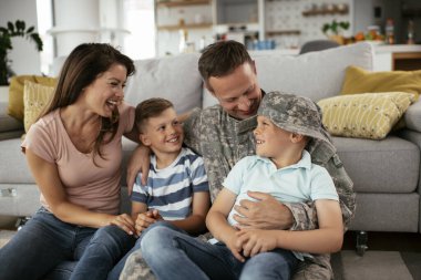 Mutlu aile kanepede birlikte vakit geçiriyor. 