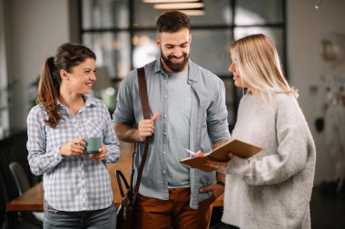 Modern açık uzay ofisinde sıradan iş adamlarından oluşan bir grup. İş kadınları ve işadamları yeni proje hakkında konuşuyor.