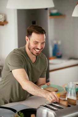 Adam mutfakta kahvaltı yapıyor.