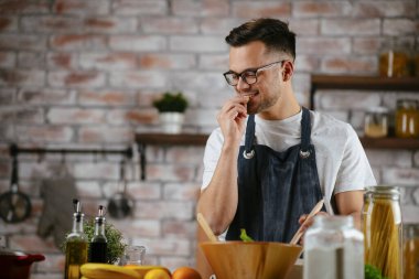 Güzel bir kadın yemek pişiriyor ve mutfakta eğleniyor. Kız mutfakta sağlıklı yemek pişiriyor..