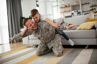 Askerler evlerinde oğluyla oynuyorlar. 