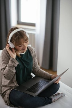 Güzel bir kadın görüntülü görüşme yapıyor. Güzel kadın evde eğleniyor..