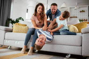 Mutlu aile kanepede birlikte vakit geçiriyor. 