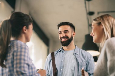 Modern açık uzay ofisinde sıradan iş adamlarından oluşan bir grup. İş kadınları ve işadamları yeni proje hakkında konuşuyor.