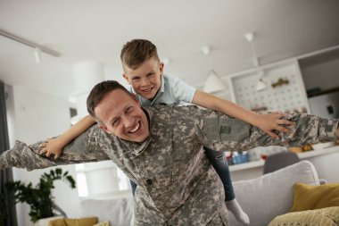 Askerler evlerinde oğluyla oynuyorlar. 