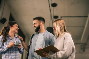Modern açık uzay ofisinde sıradan iş adamlarından oluşan bir grup. İş kadınları ve işadamları yeni proje hakkında konuşuyor.