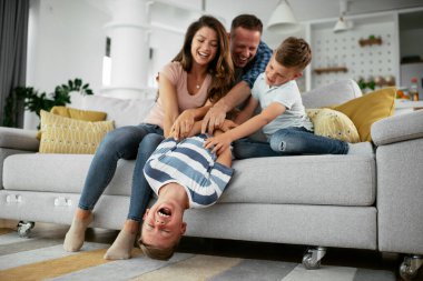 Mutlu aile kanepede birlikte vakit geçiriyor. 