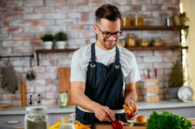 Güzel bir kadın yemek pişiriyor ve mutfakta eğleniyor. Kız mutfakta sağlıklı yemek pişiriyor..
