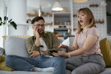 Karı koca kanepede tartışıyor. Kızgın eş kocasına bağırıyor.