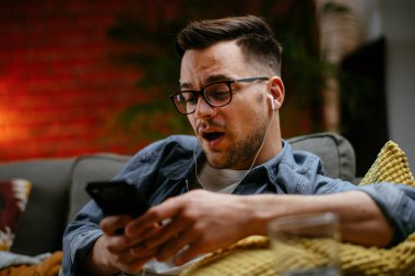 Sıradan bir adamın evde telefonuyla görüntülü konuşması. Adam apartmanında sosyal medyada sohbet ediyor..