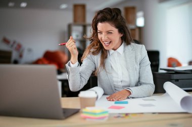 Ofiste proje üzerinde çalışan güzel bir genç kadın.