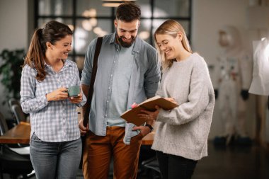 Modern açık uzay ofisinde sıradan iş adamlarından oluşan bir grup. İş kadınları ve işadamları yeni proje hakkında konuşuyor.