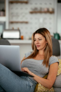 Güzel bir kadın görüntülü görüşme yapıyor. Genç mutlu kadın evde eğleniyor..