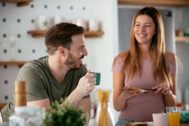 Genç çift evde sandviç yapıyor. Sevgi dolu çift mutfakta eğleniyor..