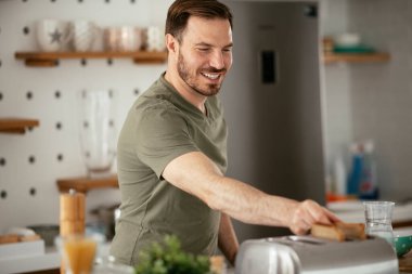 Adam mutfakta kahvaltı yapıyor.