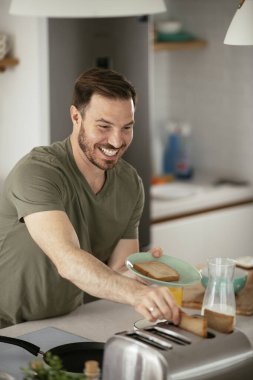 Adam mutfakta kahvaltı yapıyor.