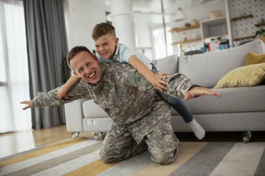 Askerler evlerinde oğluyla oynuyorlar. 