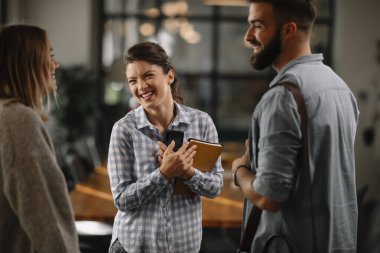 Modern açık uzay ofisinde sıradan iş adamlarından oluşan bir grup. İş kadınları ve işadamları yeni proje hakkında konuşuyor.
