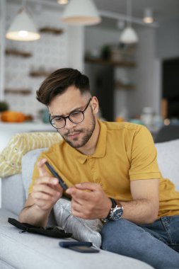 Diyabetli adam evde tükenmez kalemle kan örneği alıyor..