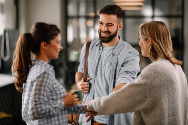 Modern açık uzay ofisinde sıradan iş adamlarından oluşan bir grup. İş kadınları ve işadamları yeni proje hakkında konuşuyor.