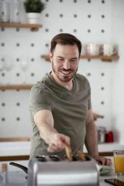 Adam mutfakta kahvaltı yapıyor.