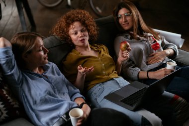 Ofiste konuşan ve gülen kızlar. Ofiste kahve içen güzel kadınlar