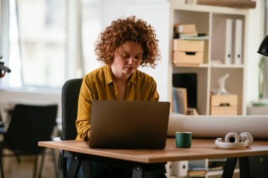 Ofiste dizüstü bilgisayarda çalışan bir kadın.