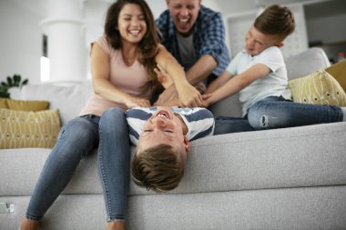 Genç bir aile evde eğleniyor. Mutlu ebeveynler ve çocuklar eğleniyor..