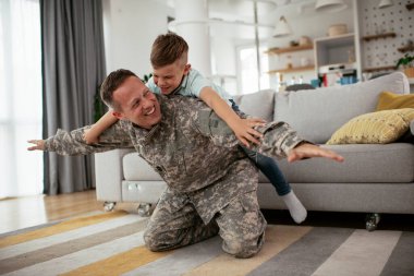 Askerler evlerinde oğluyla oynuyorlar. 