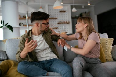 Erkek arkadaşı ve kız arkadaşı kanepede tartışıyor. Kızgın kadın erkek arkadaşına bağırıyor..