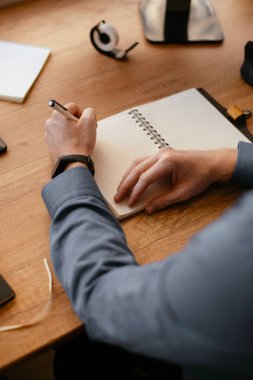 Genç kızıl iş adamı ofiste notlar alıyor.