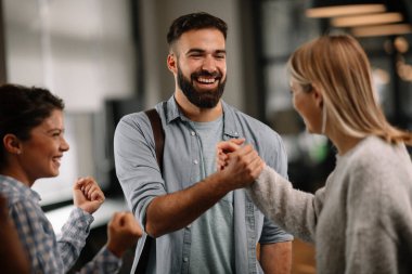 Modern açık uzay ofisinde sıradan iş adamlarından oluşan bir grup. İş kadınları ve işadamları yeni proje hakkında konuşuyor.