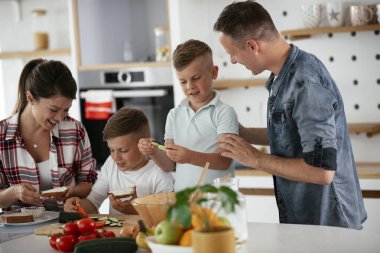 Neşeli aile kahvaltı hazırlıyor. 