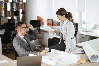 Ofiste birlikte çalışan meslektaşlar. Genç iş kadını ve işadamı yeni projede birlikte çalışıyorlar.