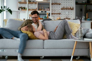 Karı koca kanepede eğleniyor. Mutlu çift oturma odasında dinleniyor..