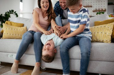 Genç bir aile evde eğleniyor. Mutlu ebeveynler ve çocuklar eğleniyor..