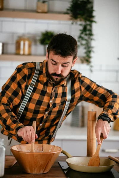 Portrait of handsome man in kitchen. Young man preparing delicious food.