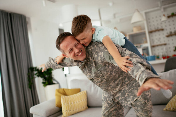 военный играет с сыном дома 