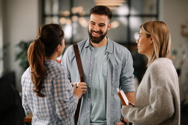 Group of casual business people talking in the modern open space office. Businesswomen and businessman talking about new project.