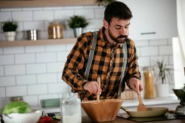 Portrait of handsome man in kitchen. Young man preparing delicious food.