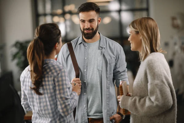 Group of casual business people talking in the modern open space office. Businesswomen and businessman talking about new project.