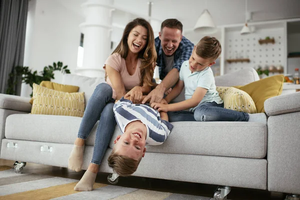 Mutlu aile kanepede birlikte vakit geçiriyor. 