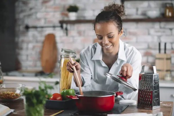Güzel bir kadın yemek pişiriyor ve mutfakta eğleniyor. Kız mutfakta sağlıklı yemek pişiriyor..