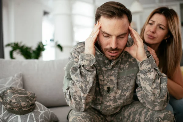 沮丧的士兵和他的妻子坐在沙发上 有创伤后精神紧张症的年轻海军陆战队员 — 图库照片