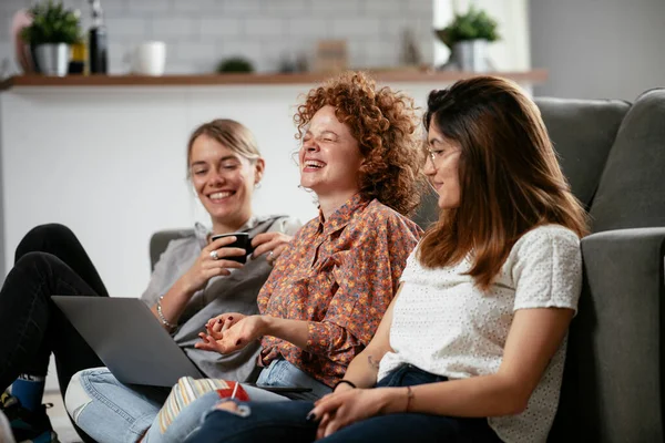 Girls talking and laughing in office. Beautiful women drinking coffee in the office