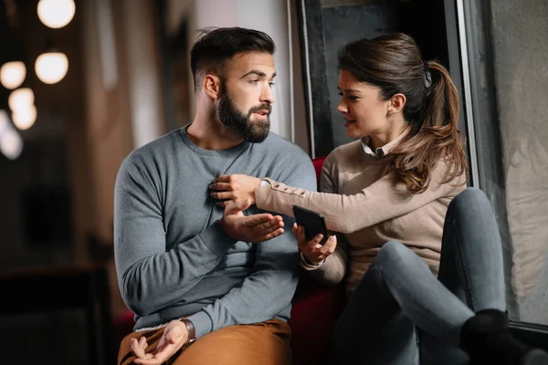 Angry couple or marriage fighting for a mobile phone at home. Jealous woman holding smartphone and showing message to his husband