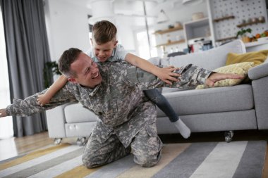 Askerler evlerinde oğluyla oynuyorlar. 