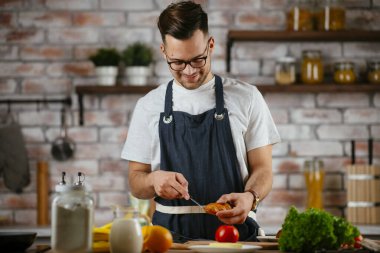 Mutfakta makarna hazırlayan yakışıklı adam. Lezzetli yemek pişiren adam..