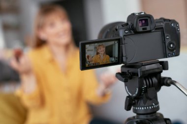 Kadın video kaydedicisi, kanalı için makyaj dersi kaydediyor. Sosyal medyada paylaşmak için makyaj dersi alan genç ve güzel bir kadın..